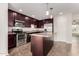 Well-equipped kitchen featuring stainless steel appliances, a center island, and dark wood cabinets at 8716 E Holly St, Scottsdale, AZ 85257