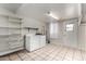 Functional laundry room with washer, dryer, shelving, and tile flooring for convenience and storage at 8716 E Holly St, Scottsdale, AZ 85257