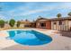 Backyard pool with clean water and patio, adjacent to a brick home and green grass at 8716 E Holly St, Scottsdale, AZ 85257