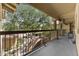 Balcony view overlooking lush trees and serene community, enhanced by iron railing and tan stucco exterior at 9100 E Raintree Dr # 239, Scottsdale, AZ 85260