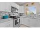 Updated kitchen with stainless steel appliances, white cabinetry, and a modern backsplash, illuminated by natural light at 9100 E Raintree Dr # 239, Scottsdale, AZ 85260