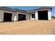 Newly constructed home exterior showing structural framing, windows, and garage bays on a desert lot at 11140 W Prospector Dr, Queen Creek, AZ 85144