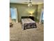 Spacious bedroom featuring ceiling fan, large windows, and neutral carpet at 13783 W Caribbean Ln, Surprise, AZ 85379