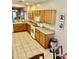 Spacious kitchen with wooden cabinets, tile flooring, and modern appliances, ideal for cooking at 13783 W Caribbean Ln, Surprise, AZ 85379