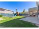 Expansive backyard featuring a play structure, trampoline, and lush green lawn at 15324 W Windsor Ave, Goodyear, AZ 85395