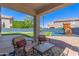 Inviting covered patio with outdoor seating overlooking a well-maintained backyard and play structure at 15324 W Windsor Ave, Goodyear, AZ 85395