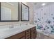 Inviting bathroom with a double sink vanity, large mirrors, and a stylish shower curtain at 15324 W Windsor Ave, Goodyear, AZ 85395
