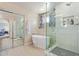 Spa-like bathroom with modern soaking tub, glass-enclosed shower, and seamless access to the Primary bedroom at 15324 W Windsor Ave, Goodyear, AZ 85395
