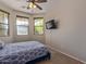 Comfortable bedroom with carpet, ceiling fan, and backyard views through multiple windows allowing natural light at 15324 W Windsor Ave, Goodyear, AZ 85395