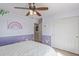 Charming bedroom with playful wall decor, ceiling fan, and a view of the closet and doorway at 15324 W Windsor Ave, Goodyear, AZ 85395