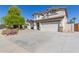 Well-kept front yard with desert vegetation and a two-story home in the background at 15324 W Windsor Ave, Goodyear, AZ 85395