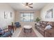 Comfortable living room with a leather sofa, accent chairs, and a large window at 15324 W Windsor Ave, Goodyear, AZ 85395