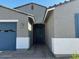 Inviting entrance with brick walkway and covered porch, leading to a blue front door at 17788 W Odeum Ln, Goodyear, AZ 85338