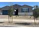 Charming single-story home featuring a blue garage door and a desert landscape at 17788 W Odeum Ln, Goodyear, AZ 85338