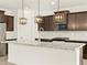Modern kitchen with granite countertops, stainless steel appliances, and dark wood cabinetry at 17788 W Odeum Ln, Goodyear, AZ 85338