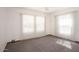 Sunny bedroom with neutral carpet, white walls, and large window with privacy blinds at 1836 W Las Palmaritas Dr, Phoenix, AZ 85021