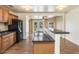 Open kitchen with wood floors features wooden cabinets, black appliances, and a breakfast bar at 1836 W Las Palmaritas Dr, Phoenix, AZ 85021