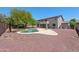 Spacious backyard featuring a pool, patio, decorative rock, lawn and mature trees at 2036 S Reseda Ct, Gilbert, AZ 85295