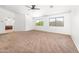 Bright bedroom featuring neutral carpet, a ceiling fan, and large windows for plenty of natural light at 2036 S Reseda Ct, Gilbert, AZ 85295