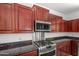 Close up of kitchen with stainless steel gas range and overhead microwave at 2036 S Reseda Ct, Gilbert, AZ 85295