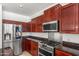 Close up of kitchen with stainless steel appliances, granite countertops, and dark wood cabinets at 2036 S Reseda Ct, Gilbert, AZ 85295
