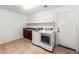 Laundry room with neutral tile flooring, cabinets, shelving, washer, and dryer at 2036 S Reseda Ct, Gilbert, AZ 85295