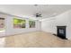 Well-lit living area featuring tile floors, a modern fireplace, and backyard views through multiple windows at 2036 S Reseda Ct, Gilbert, AZ 85295