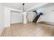 Spacious living room with staircase, neutral tile floors, and modern lighting fixture at 2036 S Reseda Ct, Gilbert, AZ 85295