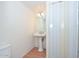 Small half bath with white walls, a pedestal sink, and white paneled door at 2051 W Elm St, Phoenix, AZ 85015