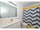 Bright bathroom featuring a white vanity and a shower with a stylish chevron curtain at 2051 W Elm St, Phoenix, AZ 85015