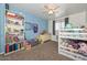 Bright, blue room with a bunk bed, large bookshelf, and carpeted floor at 2051 W Elm St, Phoenix, AZ 85015