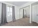 Neutral bedroom featuring window and mirrored closet doors, carpeted flooring and curtains at 2051 W Elm St, Phoenix, AZ 85015