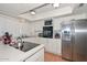 Well-lit kitchen featuring white cabinets, stainless steel refrigerator, and modern appliances at 2051 W Elm St, Phoenix, AZ 85015