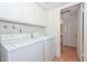Bright laundry room featuring a washer and dryer with white cabinets above at 2051 W Elm St, Phoenix, AZ 85015