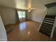 Cozy living room with wood-look floors, ceiling fan, and staircase at 2051 W Elm St, Phoenix, AZ 85015