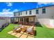 Large backyard featuring covered patio, fire pit area, hot tub, and lush artificial turf at 20812 W Legend Trl, Buckeye, AZ 85396