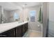Bathroom features a dual sink vanity with dark cabinets and a large mirror with tiled floor at 20812 W Legend Trl, Buckeye, AZ 85396