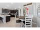 Bright dining area with dark wood table, white chairs, and natural light from large windows at 20812 W Legend Trl, Buckeye, AZ 85396