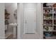 Bright hallway with a powder room, door to outside, and pantry stocked with essentials at 20812 W Legend Trl, Buckeye, AZ 85396