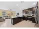 Modern kitchen with dark cabinets, stainless steel appliances, and an open layout at 20812 W Legend Trl, Buckeye, AZ 85396