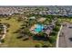 Aerial view of the community pool with palm trees, lounge chairs and a clubhouse in a residential neighborhood at 22560 E Rosa Rd, Queen Creek, AZ 85142