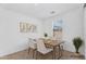 Bright dining area with a rustic wooden table, neutral chairs, and charming botanical wall art at 22560 E Rosa Rd, Queen Creek, AZ 85142