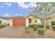 Charming single-story home with a red garage door, manicured landscaping, and inviting curb appeal at 22560 E Rosa Rd, Queen Creek, AZ 85142