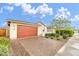Lovely single-story home with a red garage door, desert landscaping, and a brick driveway at 22560 E Rosa Rd, Queen Creek, AZ 85142