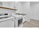 Well-lit laundry room featuring modern washer and dryer, sink, and ample cabinet space at 22560 E Rosa Rd, Queen Creek, AZ 85142