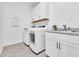 Bright laundry room with white cabinetry, washer, dryer and stainless-steel sink at 22560 E Rosa Rd, Queen Creek, AZ 85142