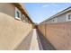 Side yard walkway with brick path between the house and a block wall, featuring desert landscaping at 22560 E Rosa Rd, Queen Creek, AZ 85142