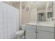 Clean bathroom featuring a vanity with a sink, a toilet, and a shower with a curtain, offering essential amenities at 2559 N 73Rd Dr, Phoenix, AZ 85035