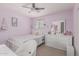Cozy bedroom with pink walls, ceiling fan, and plush bedding, providing a comfortable and inviting atmosphere at 2559 N 73Rd Dr, Phoenix, AZ 85035