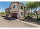 Inviting two-story home showcasing a brown garage door and lush landscaping, enhancing curb appeal at 2559 N 73Rd Dr, Phoenix, AZ 85035